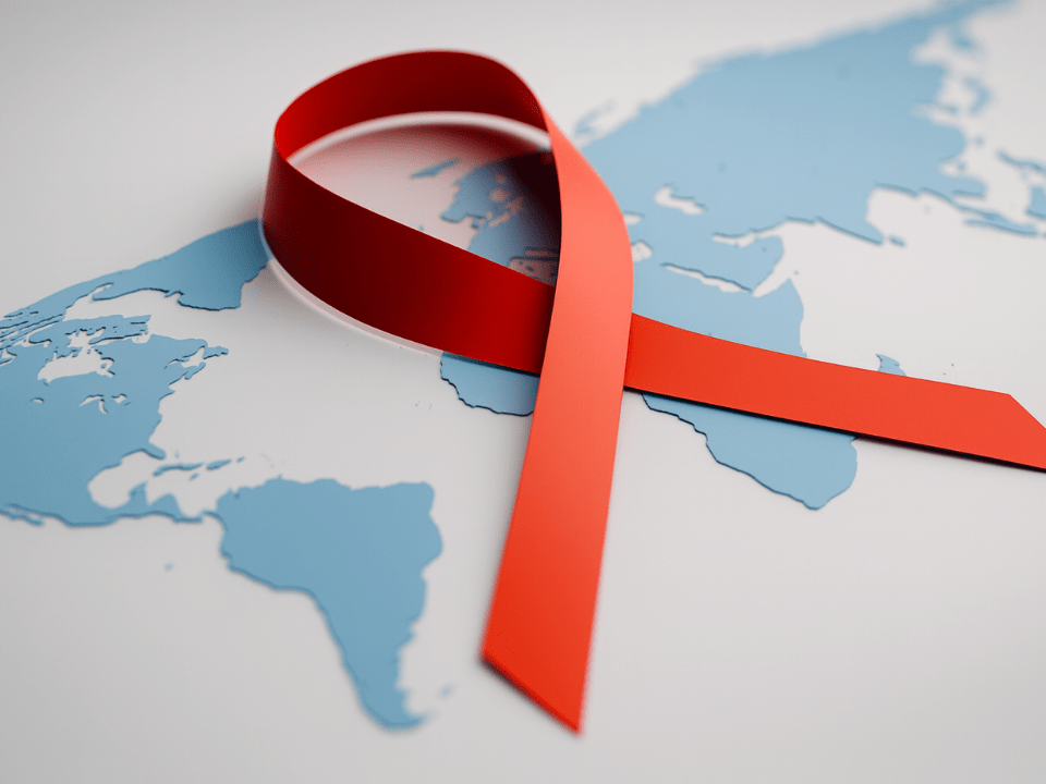Laço vermelho sobre mapa mundial simbolizando a crise de financiamento global no combate ao HIV em 2025.