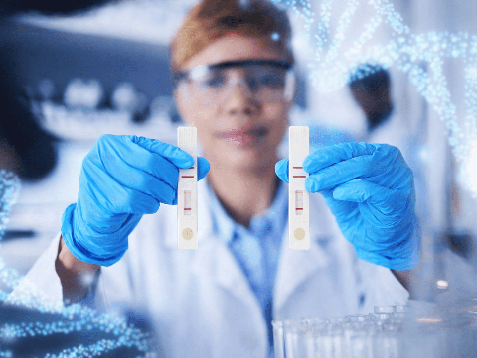 Pesquisador em laboratório segura tiras descartáveis para diagnóstico molecular, representando avanços em pesquisa, validação analítica e inovação em exames laboratoriais.