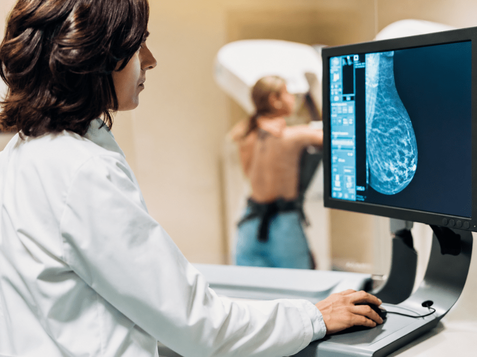 Radiologista analisa mamografia digital em estação de patologia digital em alusão a inteligência artificial para câncer de mama com tecnologia aprovada pela FDA para estratificação de risco oncológico.