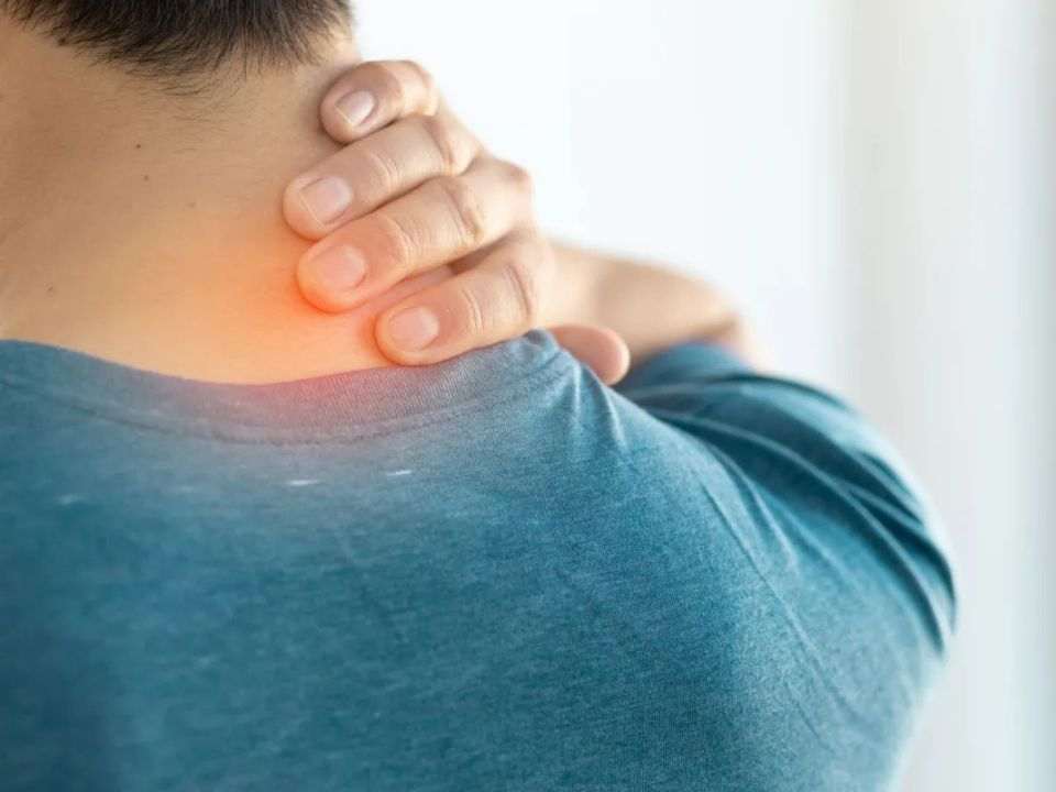 Paciente com a mão no pescoço, representando sintomas do câncer de cabeça e pescoço e reforçando a importância do diagnóstico precoce durante o Julho Verde.
