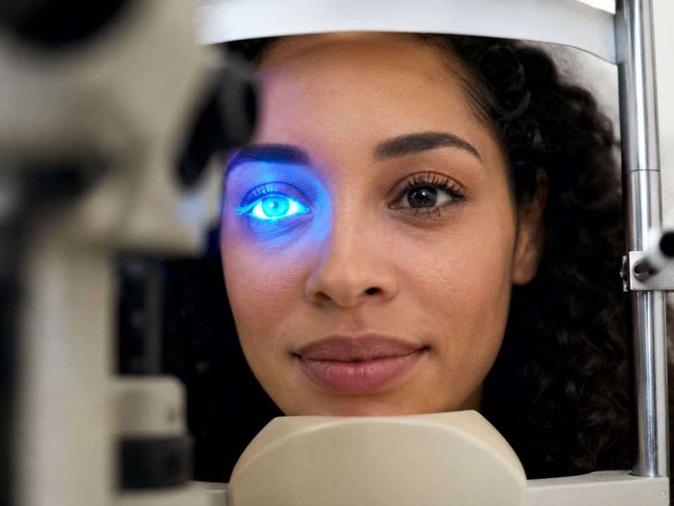 Mulher realiza exame oftalmológico com luz azul, procedimento associado à avaliação da saúde ocular e ao diagnóstico precoce de alterações na visão.